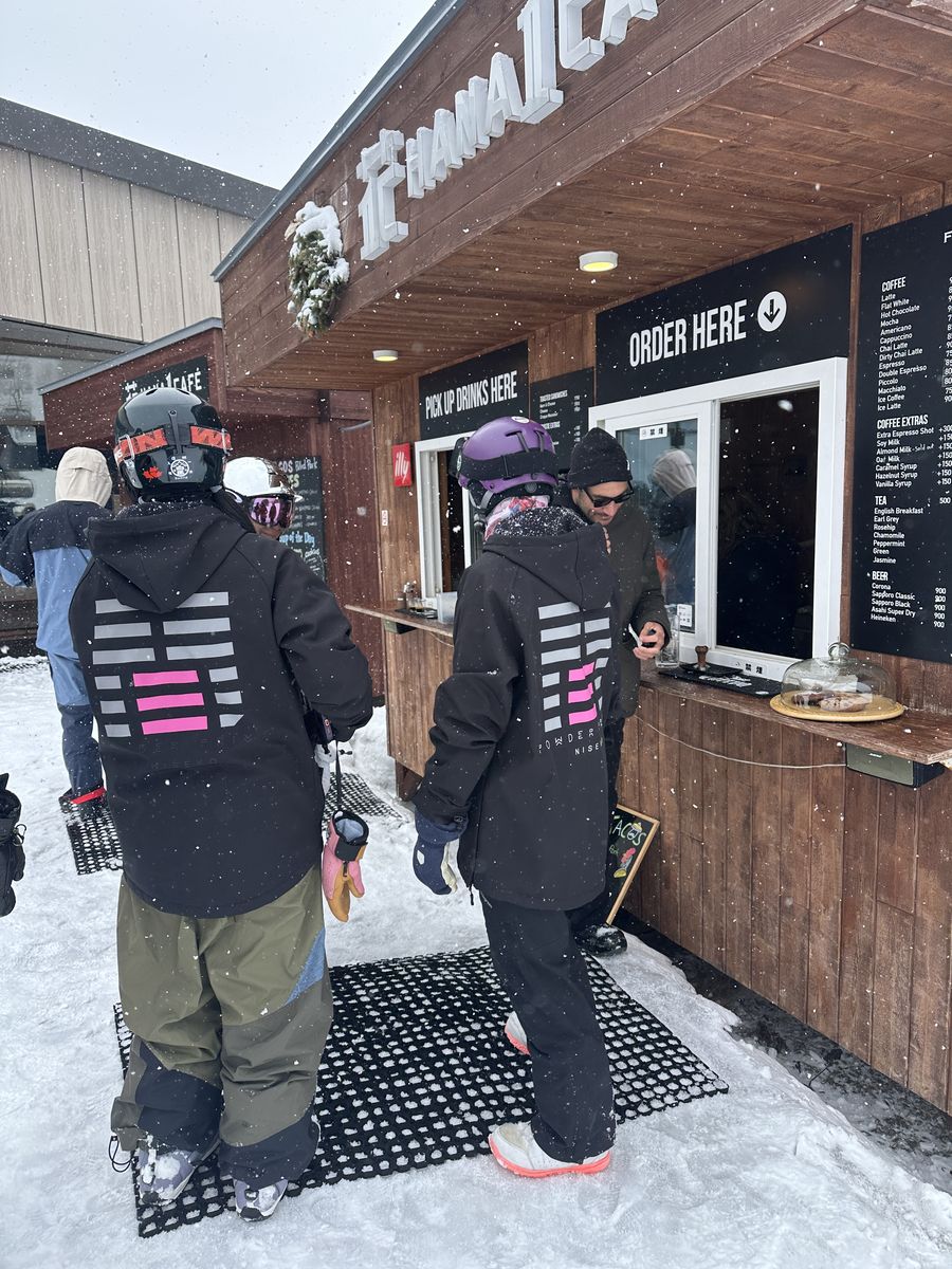 Riders in Powder Privé hoodies at a coffee stand